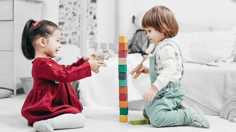 2 fillettes qui jouent avec des jouets en bois